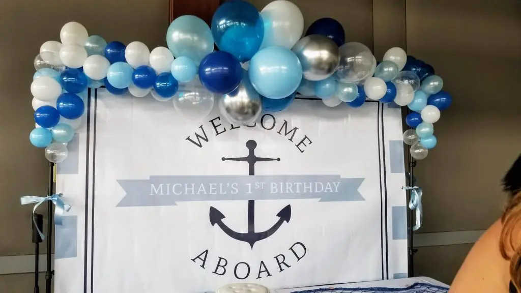 A beautiful garland of Navy Blue, White, Silver, and Light Blue latex balloons twisted together, perfect for a baby's first birthday party in New York City.