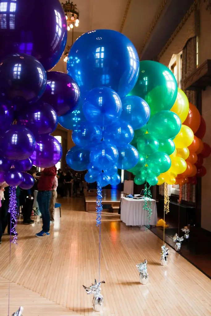 Column of purple, blue, green, red, yellow, and orange latex balloons for party decoration delivered by Balloons Lane in New York City