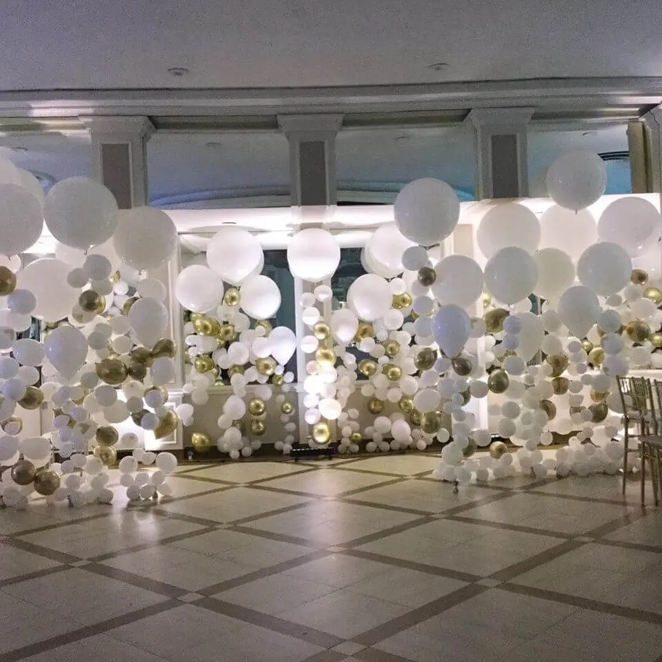 big medium and small white and gold column style balloons on strings