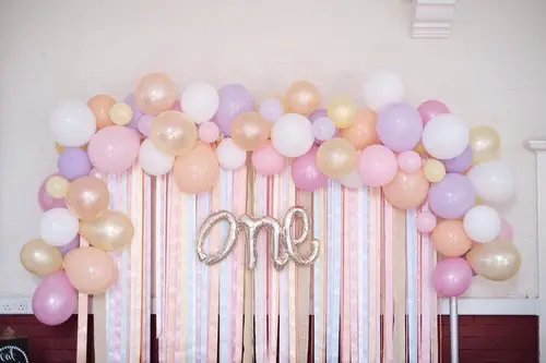 A gorgeous arch made of Rose Gold, White, Blush, Lavender, and Pink latex balloons, featuring a Silver Number One, perfect for adding a touch of elegance to any event decoration in NJ.