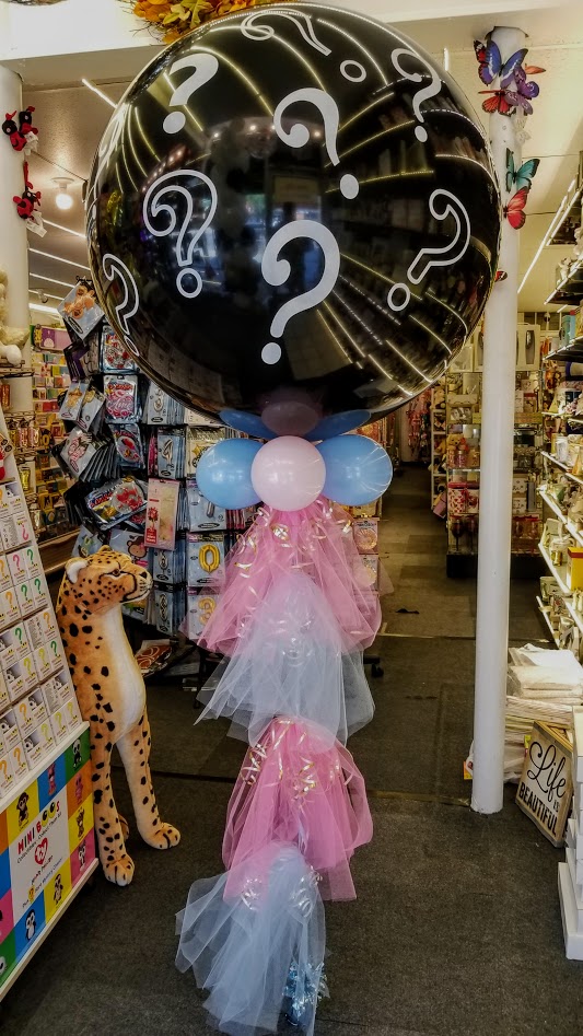 gender reveal balloon with mini pink and blue balloons and tulle tassel