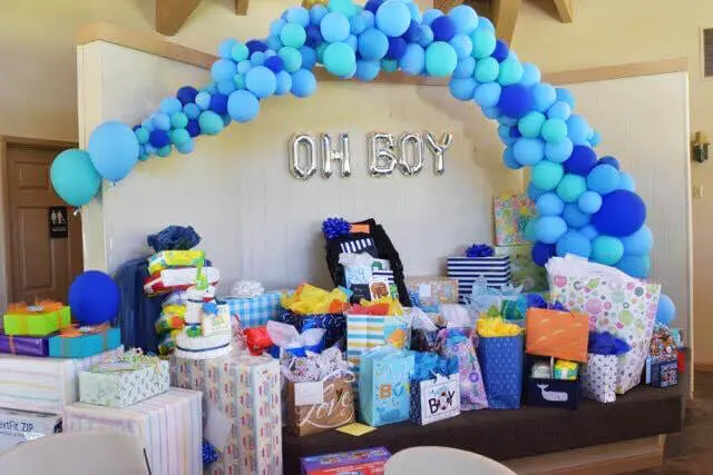 A stunning organic garland arch made of Azure and Navy Blue latex balloons, featuring "Oh Boy" balloons, perfect for adding a fun and playful touch to any decoration in NYC, delivered by Balloons Lane Balloon Delivery.