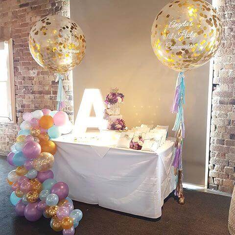 big clear communion confetti balloons with tassels and organic balloons garland around the table
