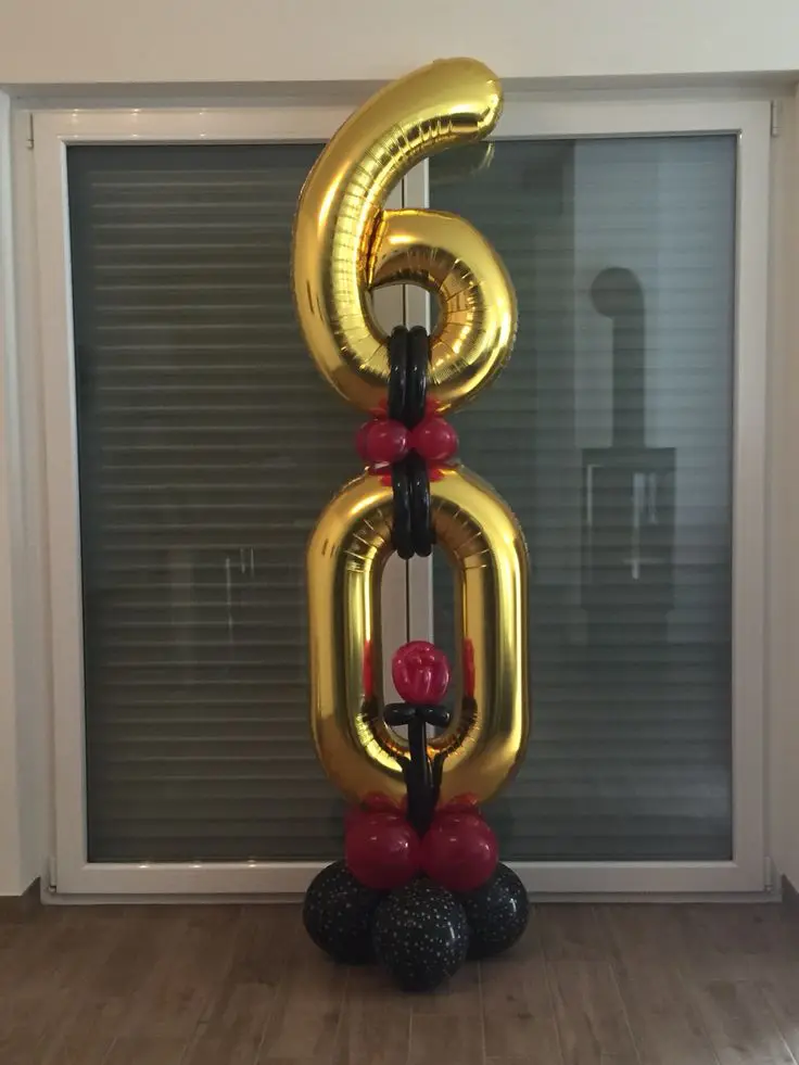6 and 0 big gold number balloons with red and black balloon in column