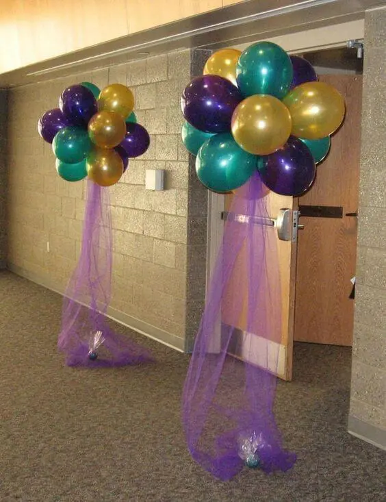 Birthday balloon column with wintergreen, gold, and purple latex balloons and silver star-shaped Mylar balloons