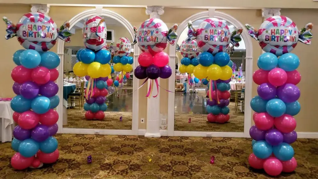 andy-themed anniversary balloon column with pink, blue, purple, and yellow balloons arranged in a spiral pattern