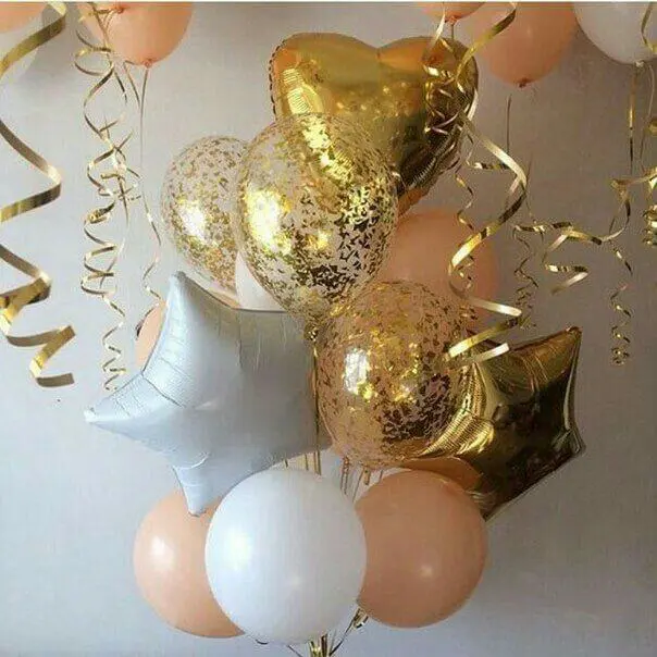 Gold confetti balloons and mylar white and gold heart balloons arranged in a decorative manner. The balloons create a playful and romantic atmosphere for any type of event.