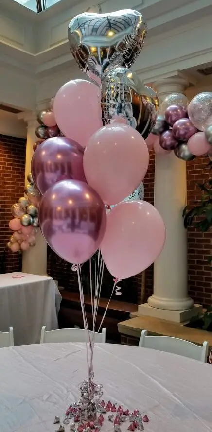 A beautiful and elegant decoration for a baby girl's first anniversary celebration, featuring a mix of Chrome® Mauve Pink, Chrome Silver, and Chrome Purple latex balloons arranged in a garland and centerpiece.