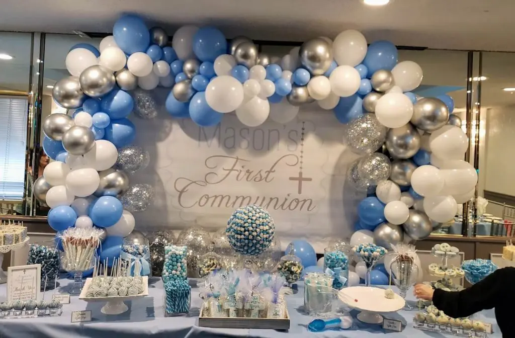 Balloons Lane in Staten Island showcases a stunning balloon garland arch made of pearlized white, light blue, and silver balloons, along with silver confetti balloons. The arrangement creates a striking display, perfect for any celebration.