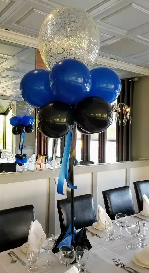 Blue and black graduation balloons with silver confetti centerpieces to celebrate your special day in a classy style