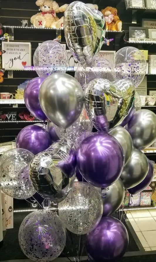 A stunning and festive decoration for an event or party, featuring purple, lavender, and silver solid chrome latex balloons and purple and silver confetti balloons arranged in a decorative manner