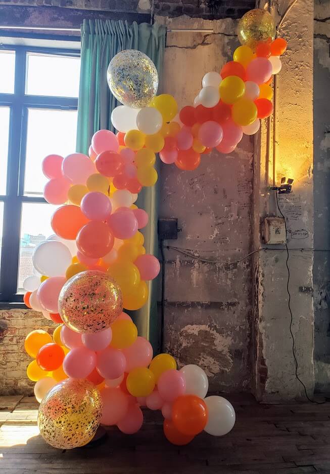 Balloons Lane in New York City Presents White Orange Pink Gold Yellow balloons Decoration.