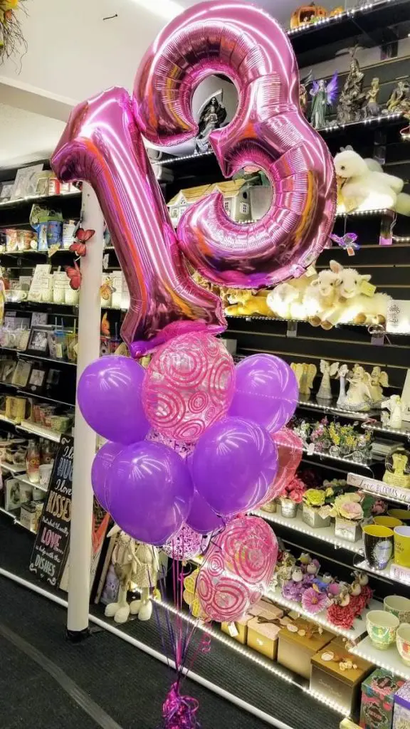 Purple and hot pink big number balloons on a pole for event decor