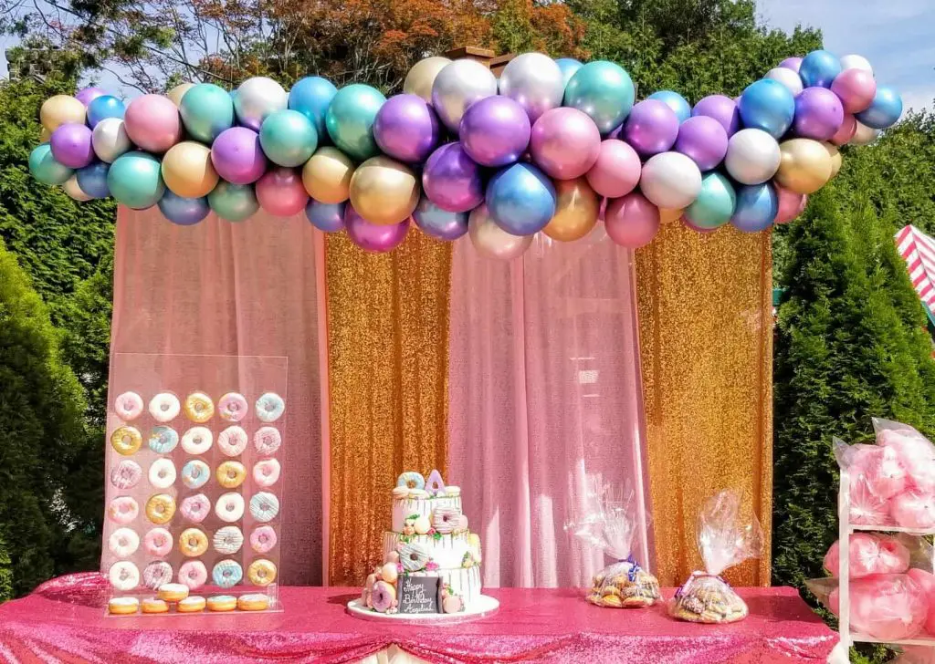 A balloon arch created by Balloons Lane in NJ for a prom event, featuring Chrome® Purple, Chrome® Blue, Chrome® Gold, and Chrome® Silver balloons as decorations. The metallic colors are vibrant and eye-catching, creating a glamorous and exciting atmosphere.