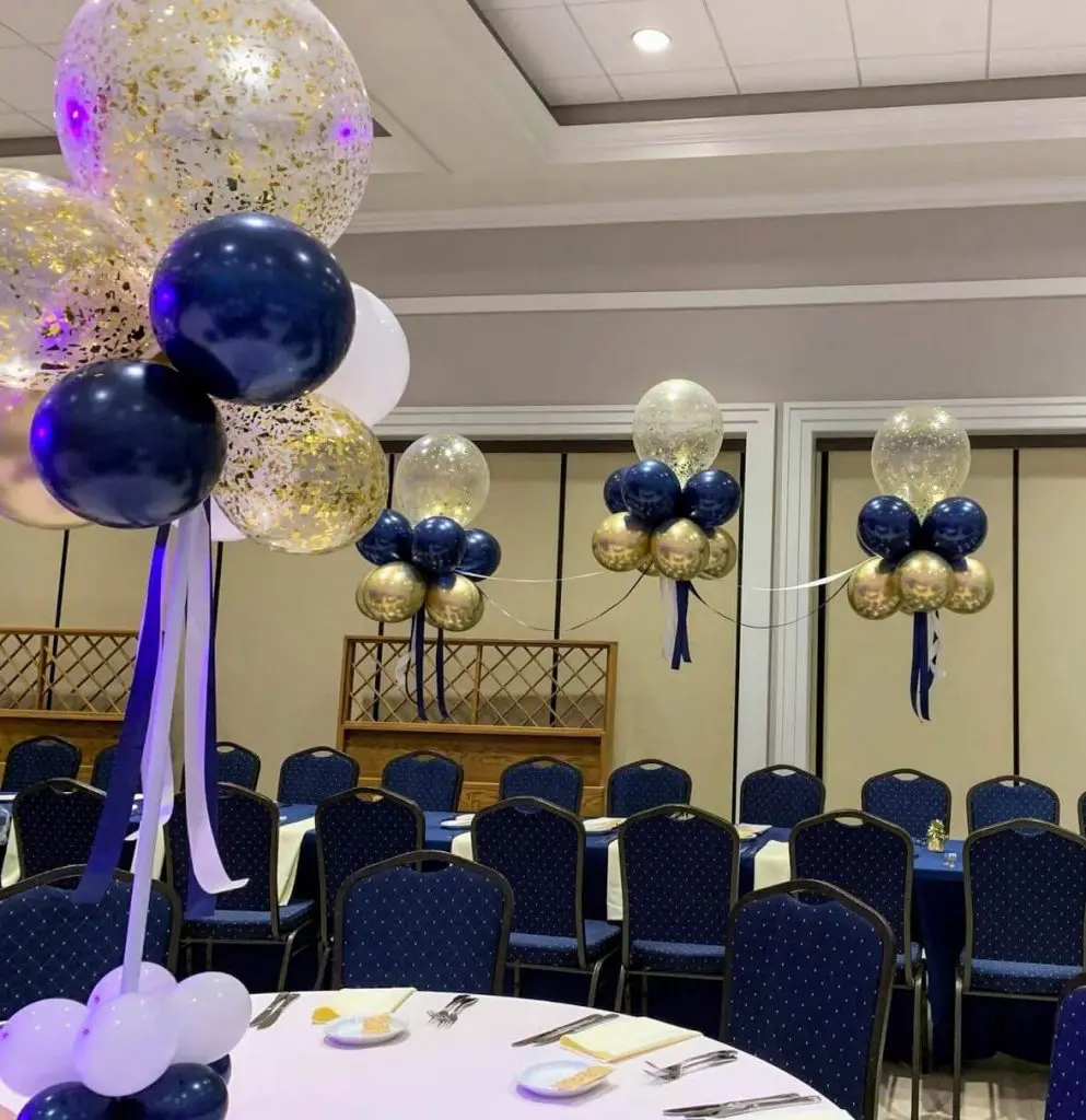 Balloons Lane in New Jersey creates elegant decorations using a mix of midnight blue, pearl white, and gold confetti balloons, tied together with silver and blue ribbon. These decorations are perfect for adding a touch of sophistication and celebration to any event.