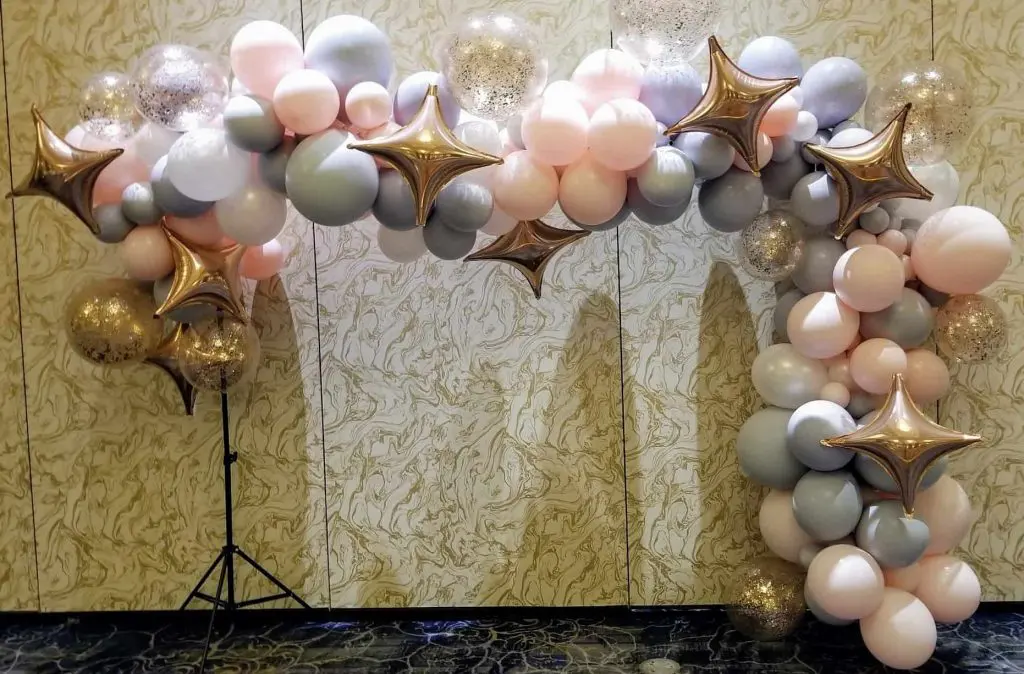 A balloon arch in pastel pink and purple colors, created by Balloons Lane Balloon in NJ for a birthday celebration. The colors are soft and delicate, creating a whimsical and charming atmosphere.