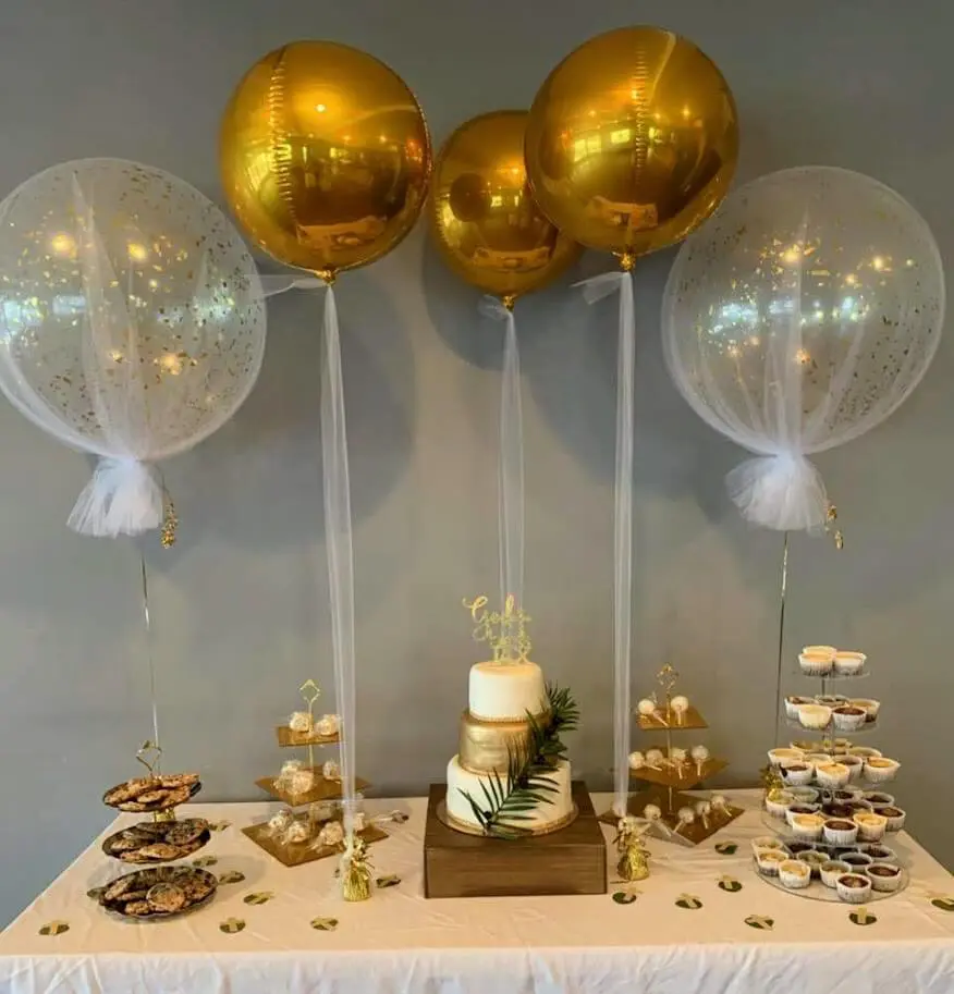 A centerpiece created by Balloons Lane in NJ, featuring gold orbz balloons and gold confetti tulle balloons.