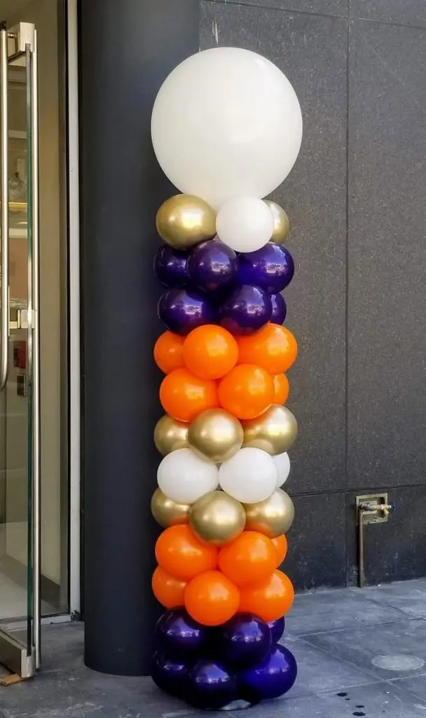 White, gold, purple, and orange latex balloon column by Balloons Lane in NYC.