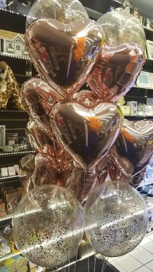 Balloons Lane creates stunning centerpieces using a mix of chrome copper and chrome rose gold rose gold balloons, along with mylar heart balloons. These decorations are perfect for adding a touch of glamour and romance to any event.