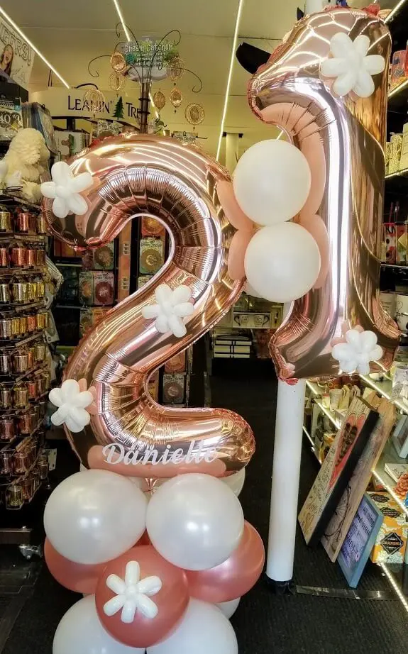 Rose gold and white balloons with big number Mylar balloons for a 21st birthday celebration.