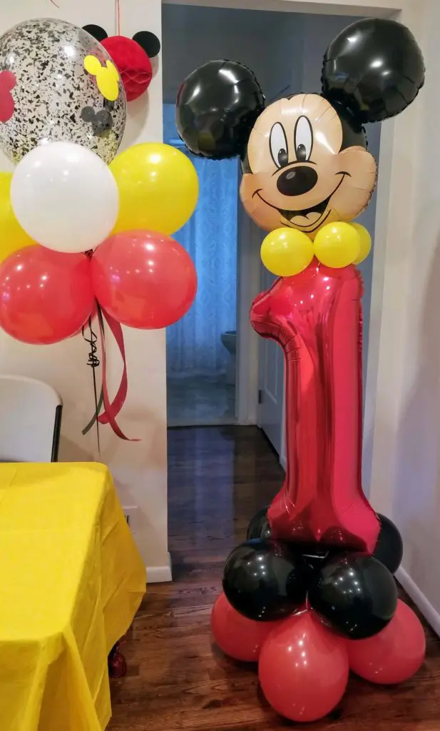 A centerpiece made of Red Rudy Red, Yellow, Black, and Blush balloons arranged in the shape of Mickey Mouse's head, with a Number 1 foil balloon in the center.