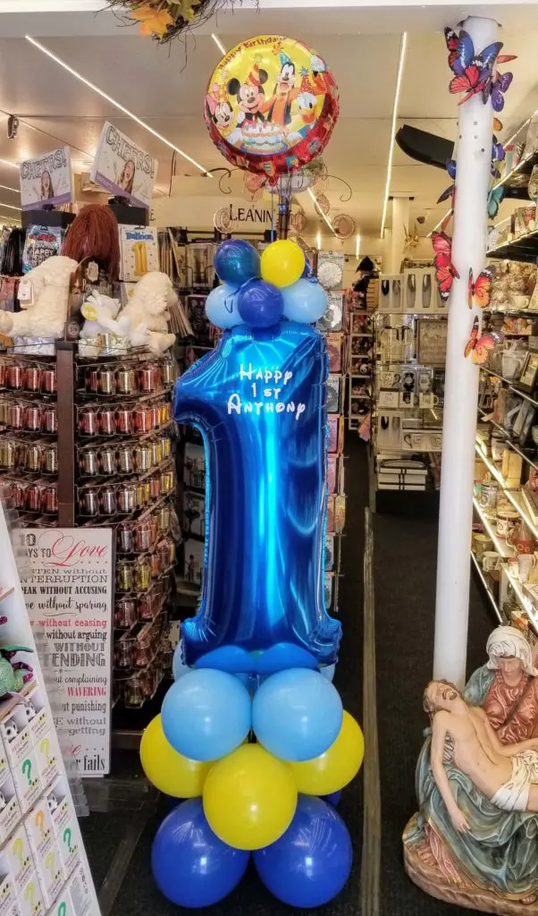 A unique balloon centerpiece in vibrant colors of Sky Blue, Yellow, Sapphire Blue, perfect for a first birthday party decoration.