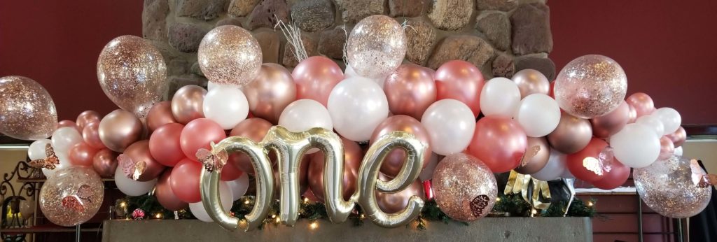 Balloons Lane Balloon delivery NYC in using colors Chrome® Mauve Chrome Rose Gold White and Silver balloons With letter Balloons one in Silver Column For first birthday