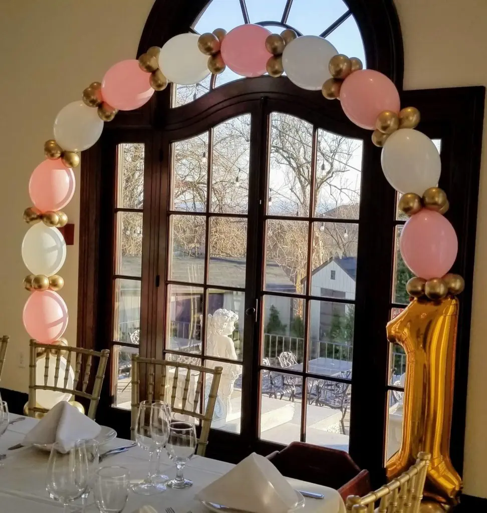 A beautiful balloon garland in Pink, White, Chrome Gold, and Gold colors, 1st Birthday party balloons Centerpiece are perfect for 1st birthday balloon decoration.