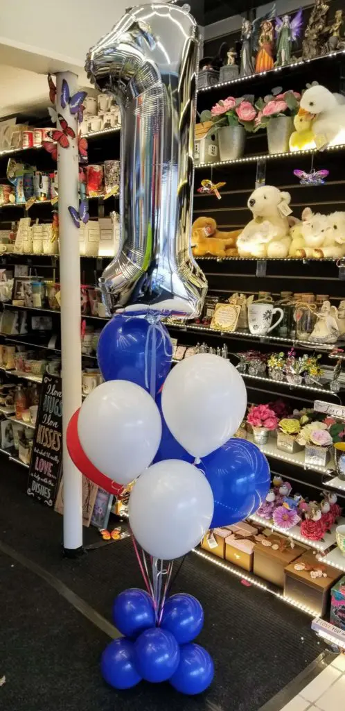A balloon arch featuring blue, red, white, and silver balloons, along with number balloons in silver, arranged for a balloon decoration in New Jersey.