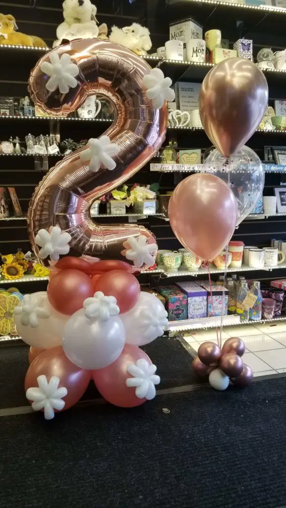 A balloon bouquet featuring mauve, rose gold, Chrome Gold, and white balloons, along with number balloons in Rose Gold, arranged in NYC.