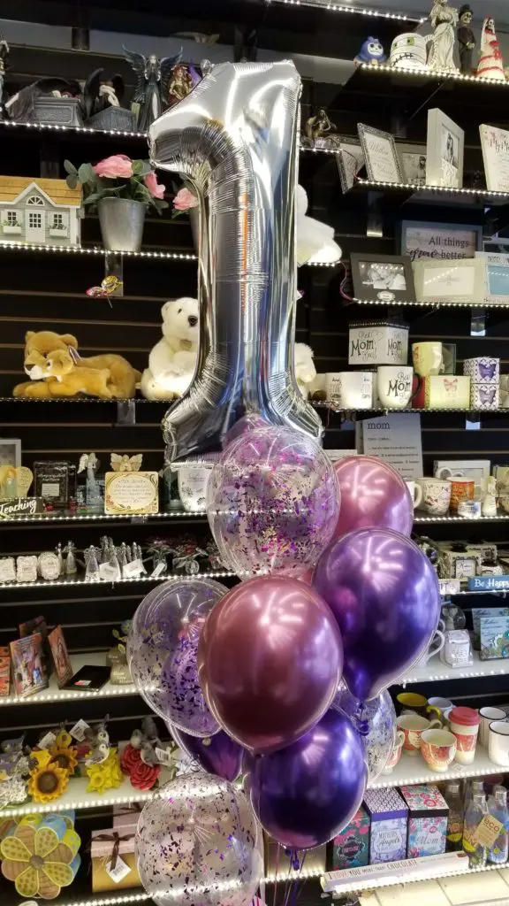 A balloon bouquet featuring purple, Chrome Mauve, and silver balloons, along with number balloons in silver, arranged for a balloon column in Staten Island.