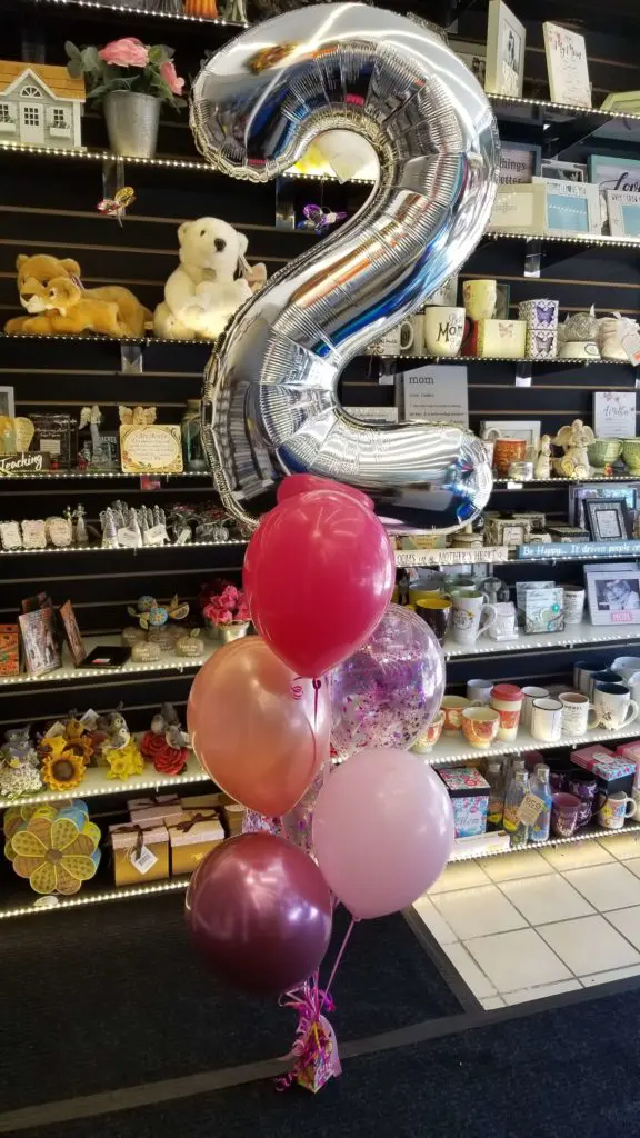 A balloon bouquet featuring pink, rose gold, Chrome Mauve, red, and silver colors, along with number balloons in silver, arranged in New Jersey.