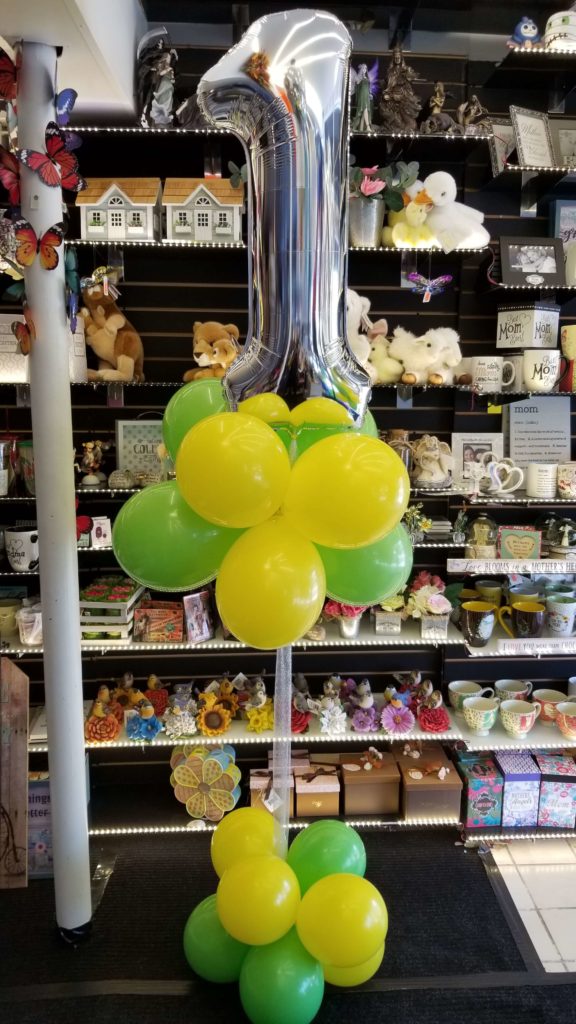 Balloons Lane Balloon delivery Soho in using colors Yellow Green and Silver balloons With Number Balloons 1in silver Column For first birthday