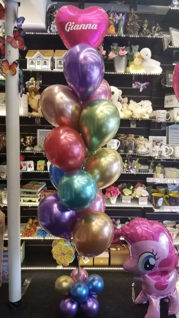A balloon garland featuring Chrome Blue, Chrome Purple, Chrome Gold, Chrome Mauve, Chrome Green, Chrome Red, Magenta balloons, and heart balloons, arranged in an arch for a 1st birthday celebration in New Jersey.