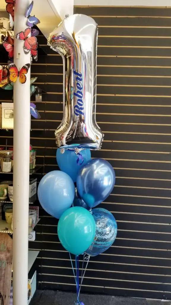 Chrome Blue, Azure, Mini Green, and Silver balloons with Number Balloons 1 in a Silver Column for Balloon Decorations in NYC.