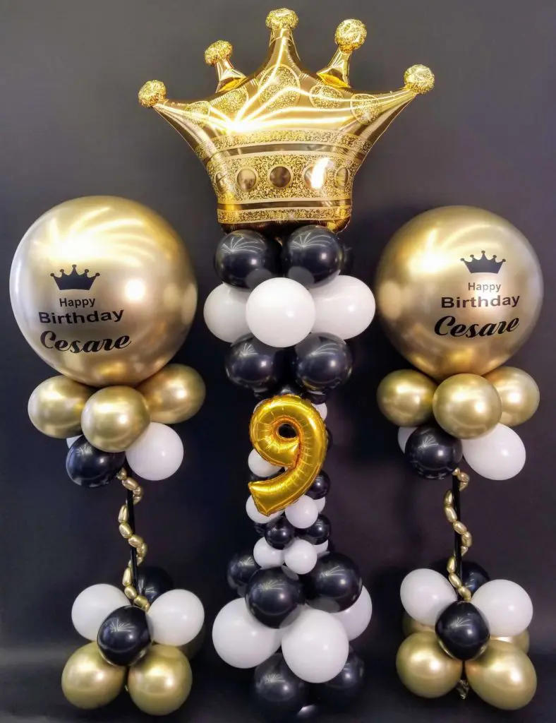 Chrome gold, black, and white balloon decorations with big round balloons and a customized crown for a 9th birthday party in NYC.