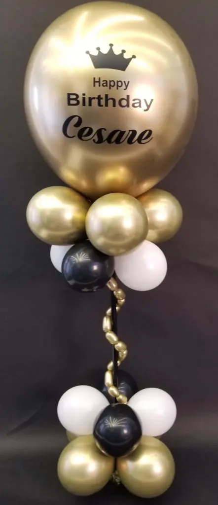 Chrome gold, black, and white balloon bouquet with big round balloons for a first birthday party by the ocean in NYC.