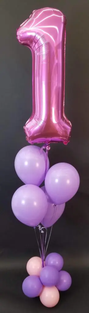 A vibrant balloon column in pink, purple, and magenta colors, featuring a magenta number 1 balloon, created by Balloons Lane in Brooklyn for a first birthday celebration.