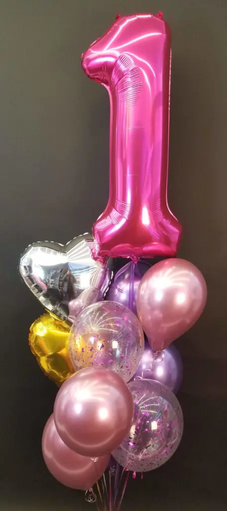 Balloons Lane using colors A beautiful and colorful balloon centerpiece in pink, purple, gold, silver, and magenta colors, featuring a magenta number 1 balloon, created by Balloons Lane in NYC for a first birthday celebration.