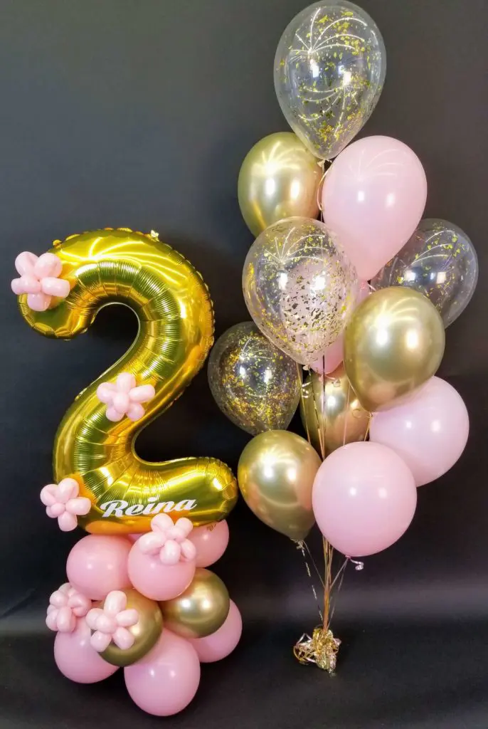 First birthday balloon decorations with gold, pink, chrome gold, and white balloons, with number balloons 2 in gold.