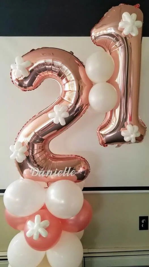 A lovely balloon arrangement with peach pink number 2 and 1 balloons, along with white and pink balloons in the background, created by Balloons Lane in NYC.
