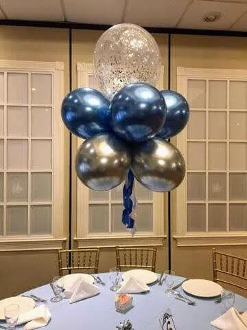 A beautiful balloon arrangement featuring blue and grey chrome balloons, along with a clear balloon filled with confetti, perfect for a christening.