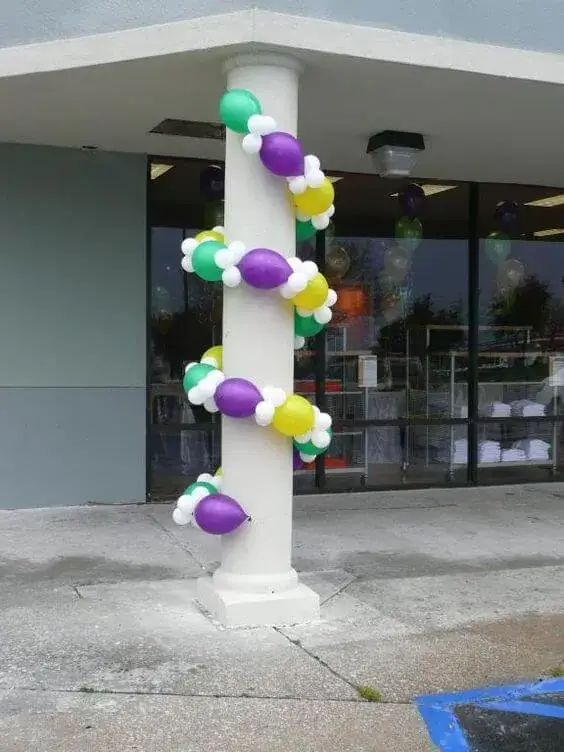 A colorful and vibrant balloon garland featuring purple, white, green, and yellow balloons, perfect for adding a festive touch to any event.