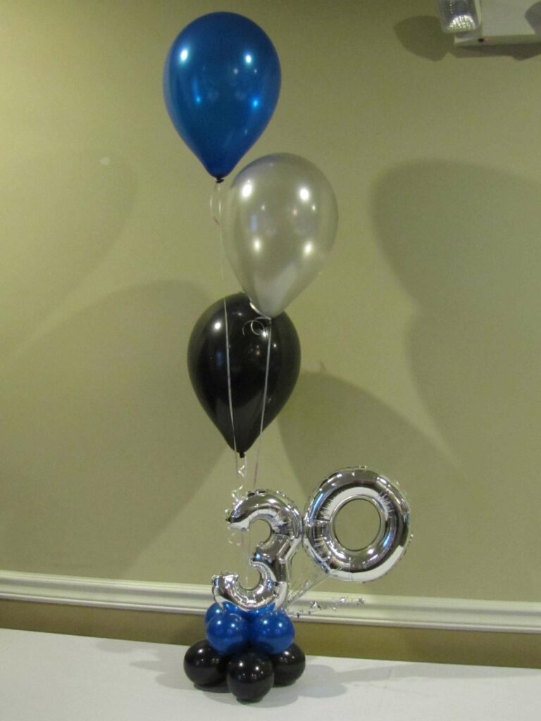 Silver number 3 and 0 balloons surrounded by a blue, black, and white balloon bouquet.