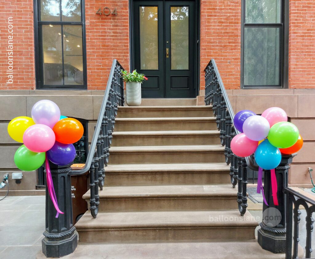alloon Lane in NJ creates festive Easter party decorations using an array of colorful balloons in shades of green, purple, pink, yellow, dark blue, orange, and light purple, displayed on the front stairs of a house.