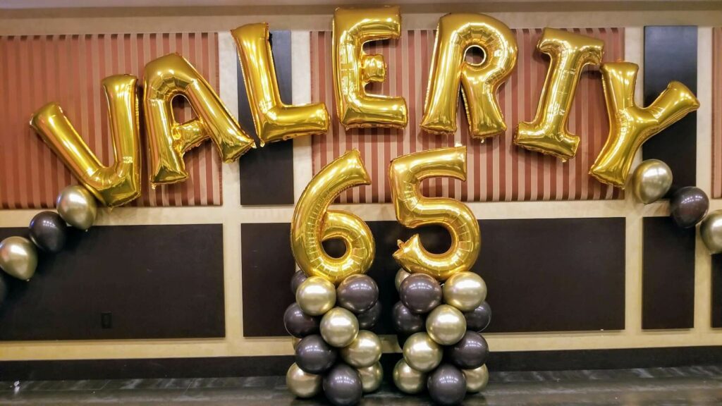 Stylish balloon arch with brown and gold chrome balloons and a large 65th birthday number, perfect for milestone birthday celebrations