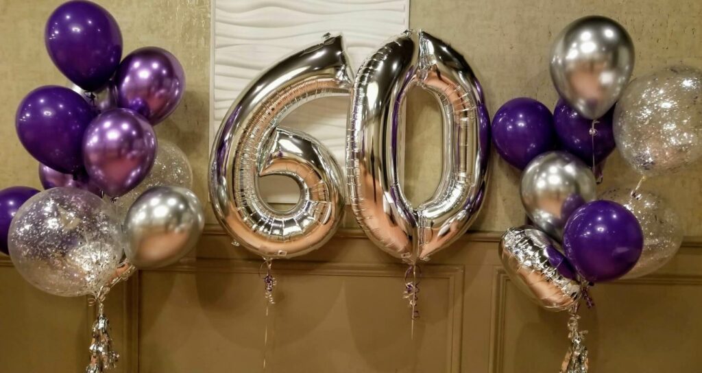 Vibrant balloon bouquet with silver big number 60th birthday balloons, chrome purple and chrome silver balloons, and confetti balloons, perfect for milestone birthday celebrations