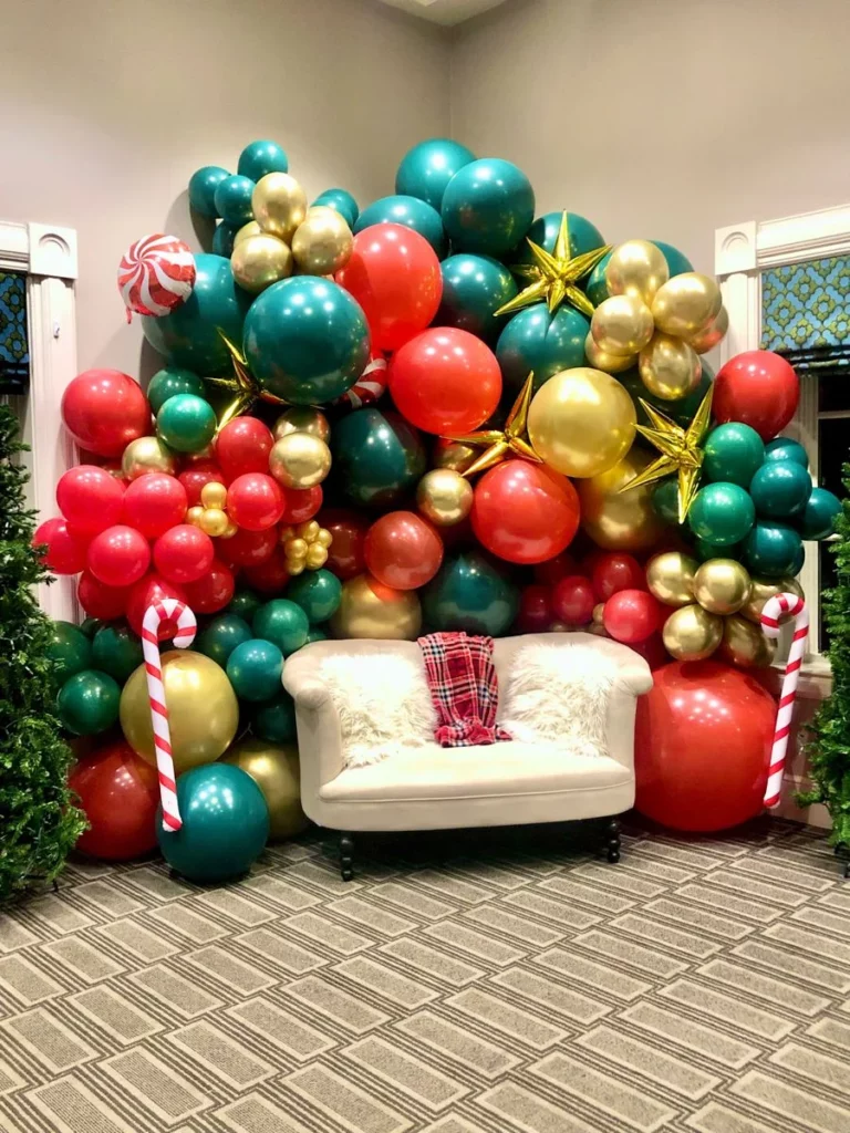 Creative and unique Christmas balloon arrangement featuring candy balloons in festive red, green, gold, and dark green colors, complemented by a latex balloon backdrop.