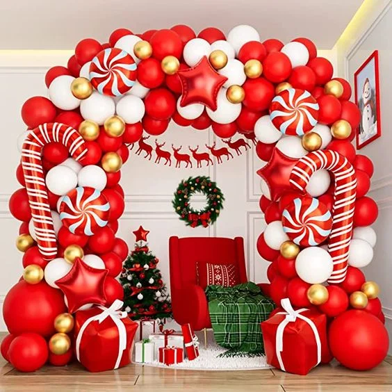Christmas party balloon arch in Santa candy shades featuring red and white latex balloons, star Mylar balloons, big red balloons, and a festive gift balloon garland.