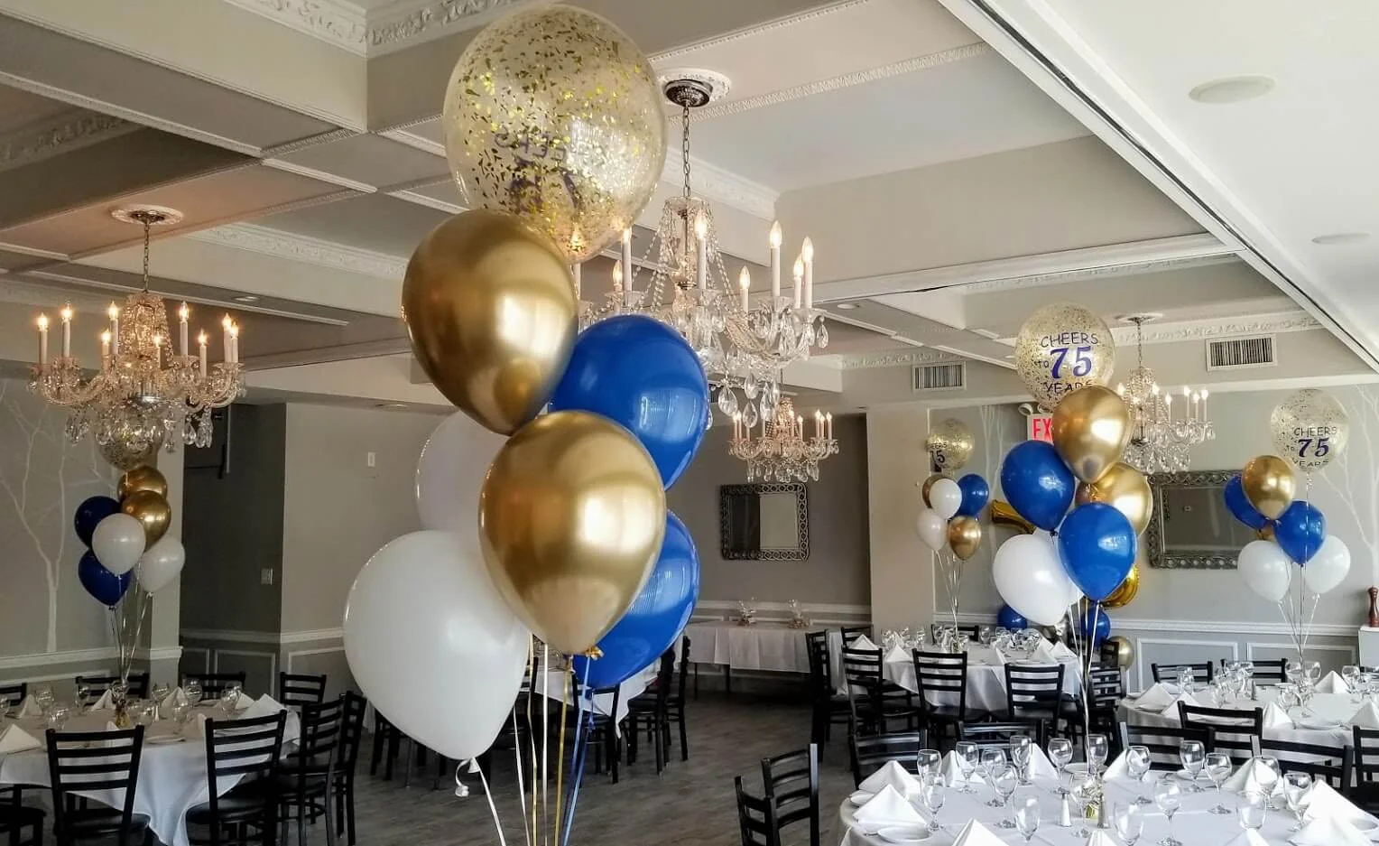 Balloons Lane's festive balloon centerpiece in Staten Island, showcasing blue, gold, and white confetti balloons arranged down the center of a table, adding a fun and celebratory touch to a birthday party.